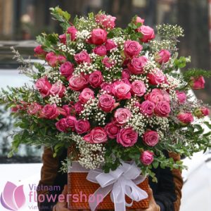 Purple roses and baby breathes arrangement basket